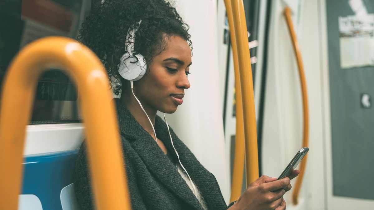 african american woman listening to music on the subway